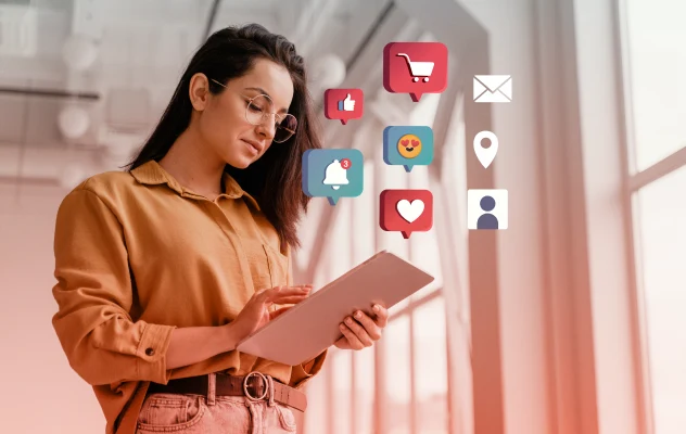 A woman using a tablet with digital marketing icons on it.